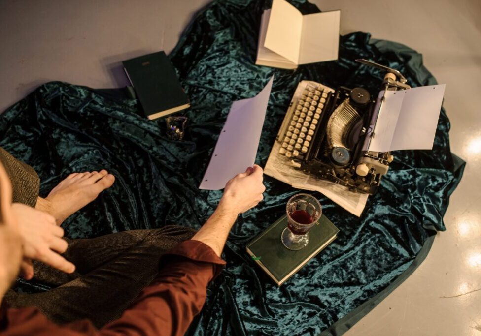 Person with typewriter and papers on fabric.