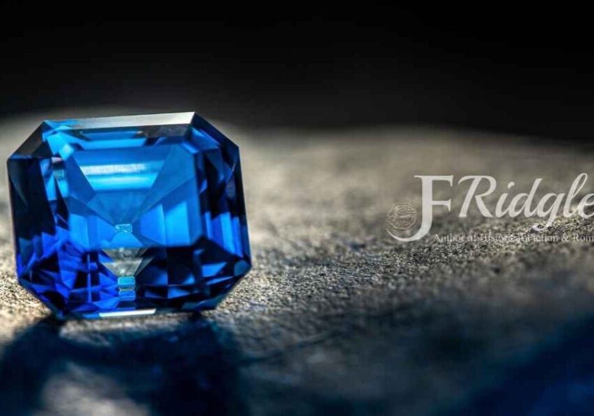 Blue gemstone on textured dark surface.